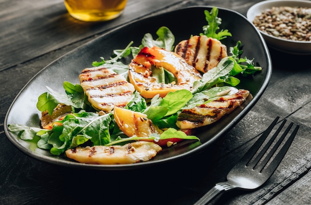 Ensalada de queso Halloumi a la plancha con melocotón y rúcula.