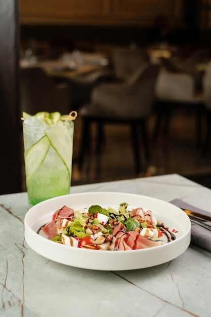 Ensalada con queso jamón y fruta con cóctel frío Sirviendo comida en un restaurante