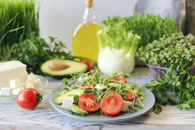 Ensalada de queso de tomates aguacate microgreens y rúcula en un plato