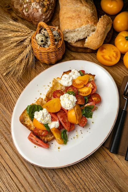 Ensalada con queso, tomates en crutones sobre una mesa de madera