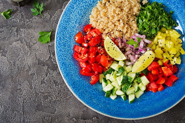 Ensalada con quinua, rúcula, pimientos dulces, tomates y pepino en un tazón