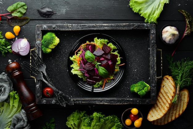 Ensalada de remolacha con cebolla en un plato negro sobre un fondo negro Vista superior Espacio libre para su texto