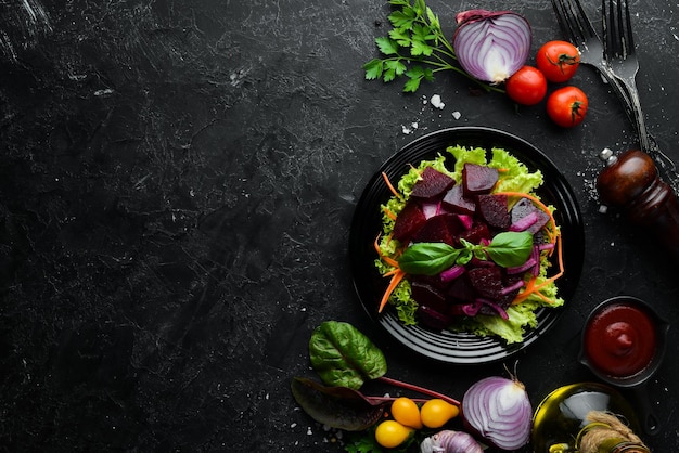 Ensalada de remolacha con cebolla en un plato negro sobre un fondo negro Vista superior Espacio libre para su texto