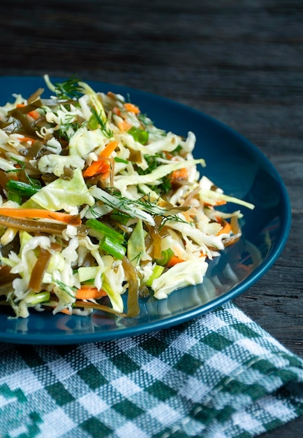 Ensalada de repollo blanco algas zanahorias y hierbas en un primer plano de la placa Ensalada de verduras frescas Plato vegetariano