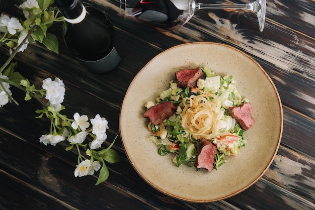 Ensalada de rosbif medio hecho con mix verde y vino