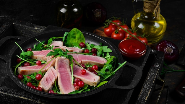 Ensalada de rúcula, atún y aguacate en un plato de piedra negra Vista superior Espacio libre para texto