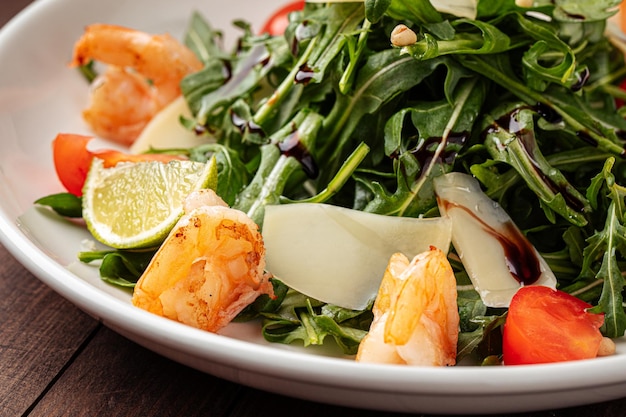 Ensalada de rúcula con camarones en el fondo de madera