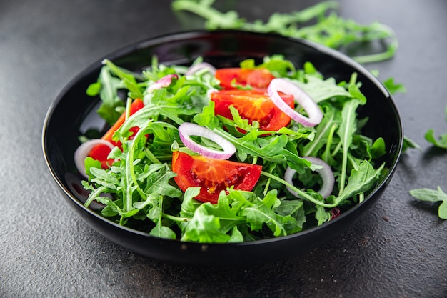 Ensalada rúcula tomate cebolla plato de verduras frescas comida snack en la mesa copia espacio comida