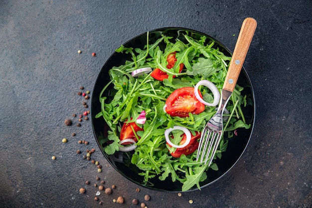 Ensalada de rúcula y tomate, vegetales en un plato, comida fresca, bocadillo en la mesa, espacio de copia de alimentos