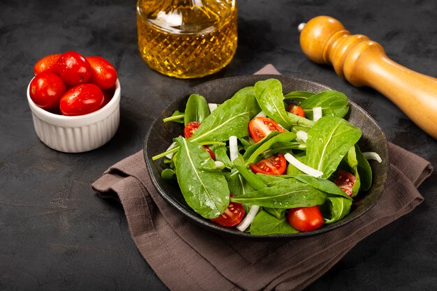 Ensalada de rúcula con tomates sobre fondo oscuro