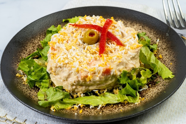 Ensalada rusa en mesa de mármol