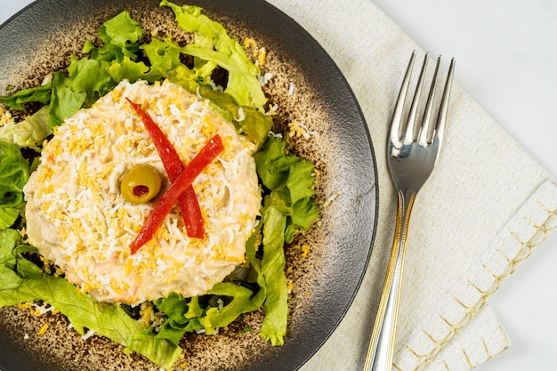 Ensalada rusa en mesa de mármol