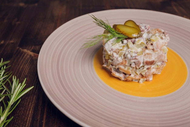 Ensalada rusa tradicional también llamada ensalada olivier en una mesa de madera vintage