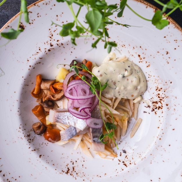 Ensalada sabrosa con manzana de arenque y champiñones en un plato Vista superior