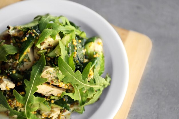 Ensalada sabrosa con pepinos de pollo y rúcula en un plato