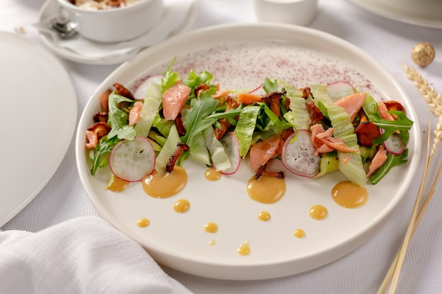 Ensalada de salmón con champiñones sobre fondo blanco.