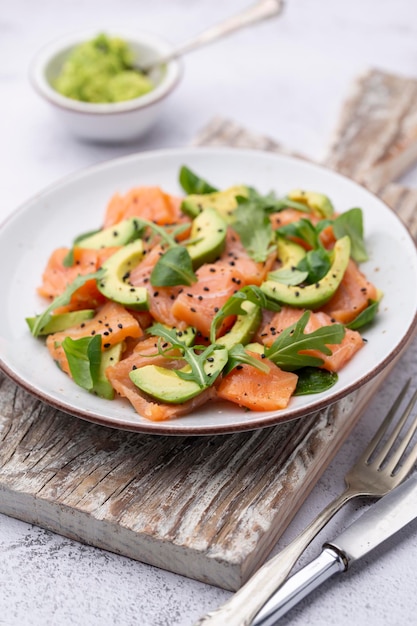 Ensalada de salmón fresco con aguacate, para dieta keto y baja en carbohidratos. Fondo oxidado, vista superior, espacio de copia.