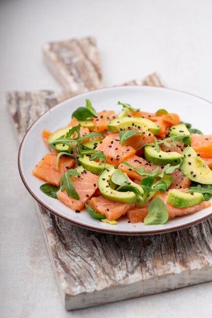 Ensalada de salmón fresco con aguacate, para dieta keto y baja en carbohidratos. Fondo oxidado, vista superior, espacio de copia.