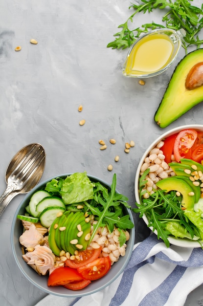 Ensalada de salmón con frijoles blancos, tomates, pepinos, aguacate y rúcula