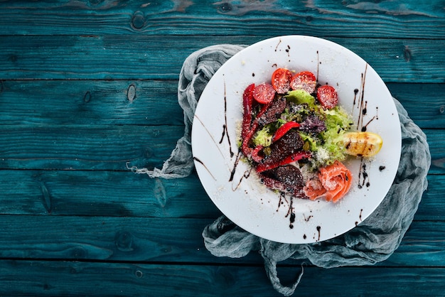 Ensalada con salmón y tomates Cocina italiana Sobre un fondo de madera Vista superior Espacio de copia