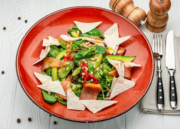 Ensalada de salmón con verduras de espinacas y piñones