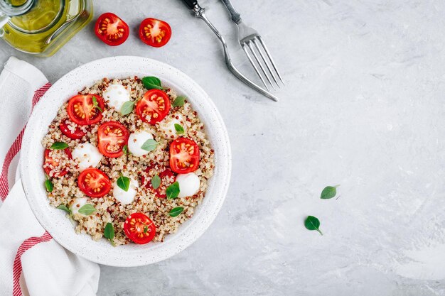 Ensalada saludable para el almuerzo con quinoa, queso mozzarella, tomates y albahaca