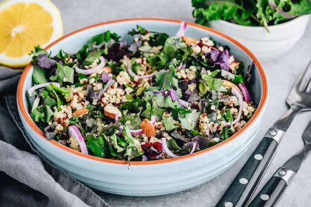 Ensalada saludable de col rizada y quinoa con arándanos secos, cebollas rojas y almendras