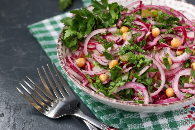 Foto ensalada saludable con garbanzos, papas, cebollas rojas y pepinos en vinagre en un plato