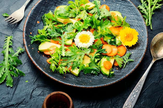 Ensalada saludable con hojas de crisantemo y aguacate, zanahorias y verde Ensalada verde fresca de verano con flores comestibles