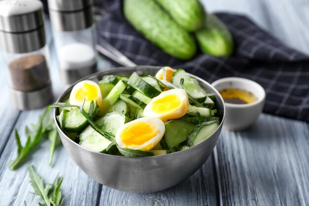 Ensalada saludable con pepinos y huevos en un tazón en la mesa