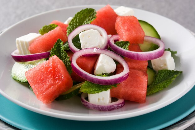 Ensalada de sandía con queso feta, menta, cebolla y pepino en gris Cerrar