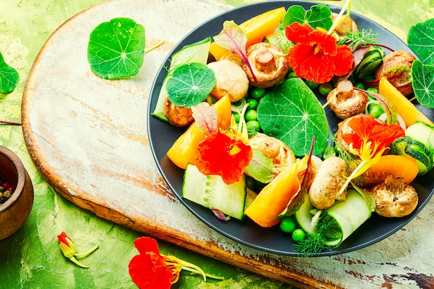 Ensalada de setas guisadas, pepino, tomate y capuchina.