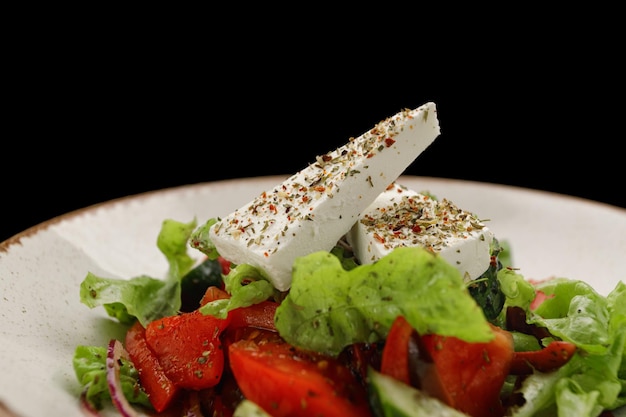 Ensalada Shopsky con queso y verduras en un plato blanco