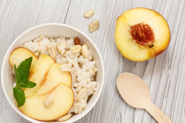 Ensalada de sorgo con nueces y melocotón fresco en tablas grises