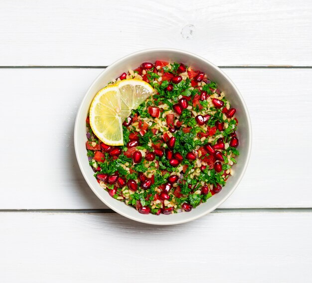 Ensalada tabulé con bulgur, menta, perejil, tomate y granada. Alimentación saludable. Comida vegetariana.