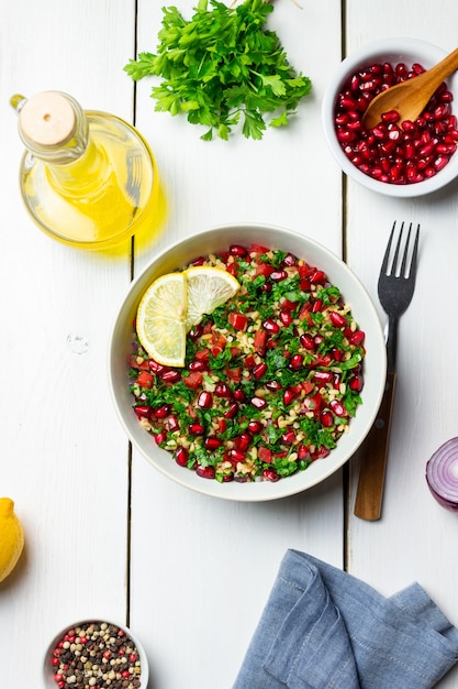 Ensalada tabulé con bulgur, menta, perejil, tomate y granada. Alimentación saludable. Comida vegetariana.