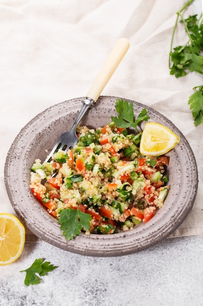 Ensalada tabulé en un recipiente con limón en una servilleta