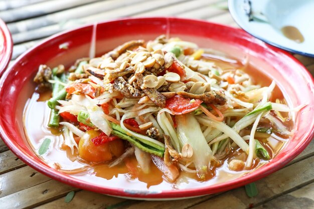 Foto la ensalada tailandesa de papaya picante en la mesa