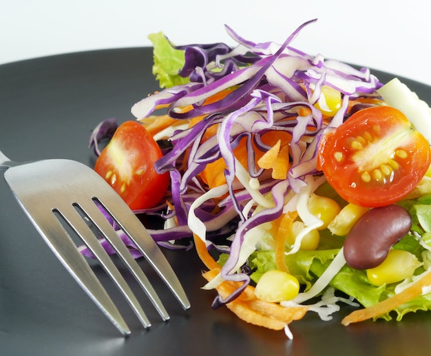 Ensalada de tenedor y cuchara en un plato negro