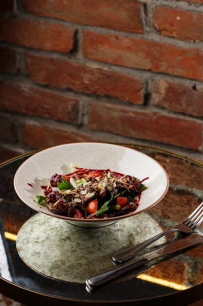 Foto ensalada con ternera y tomates filete de ternera con mezcla de verduras crudas vista lateral carne a la parrilla con guarnición primer plano delicioso plato principal en la mesa