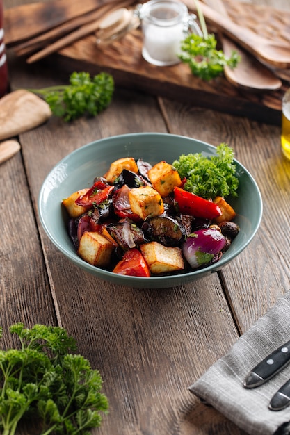 Ensalada tibia de berenjena con verduras en un bol