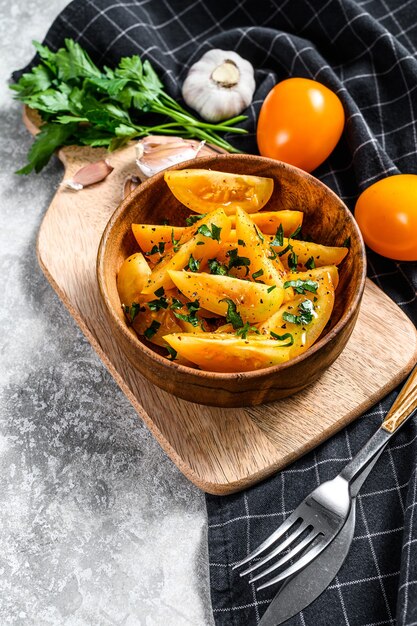 Ensalada de tomate fresco amarillo con alcaparras, aceite de oliva y perejil