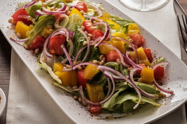 Ensalada con tomate pimiento y cebolla, Comida sana, Ensalada de verduras de temporada en blanco