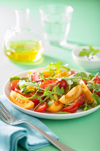 Ensalada de tomate con rúcula sobre fondo verde