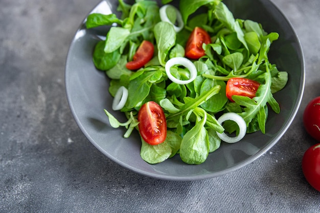 Ensalada de tomate vegetal, cebolla, mezcla de lechugas, mache verde fresco y saludable comida comida snack dieta