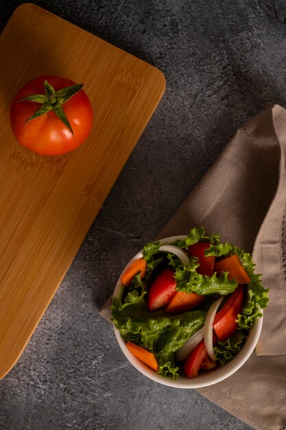 Ensalada de tomates dentro de un tazón blanco sobre la tela