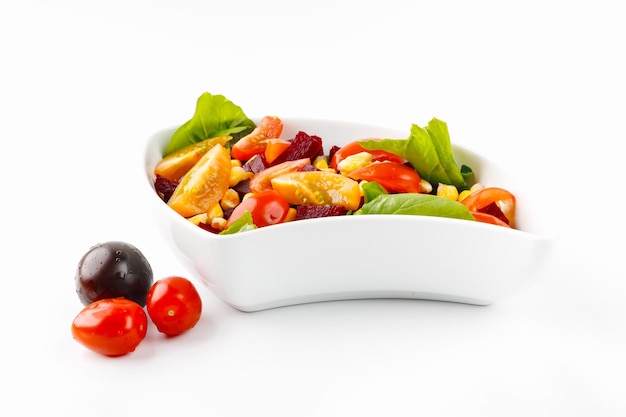 Foto ensalada con tomates de maíz y aceitunas en un tazón blanco