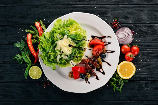 Ensalada con tomates rúcula y tomates ahumados Sobre un fondo de madera Vista superior Espacio de copia