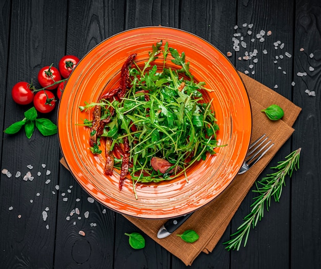 Ensalada con tomates secos, rúcula y hierbas