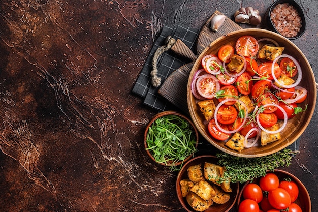 Ensalada toscana Panzanella Ensalada clásica vegetariana con tomates cebolla y picatostes Fondo oscuro Vista superior Espacio de copia